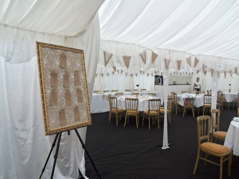 A Table plan on an easel inside a wedding marquee