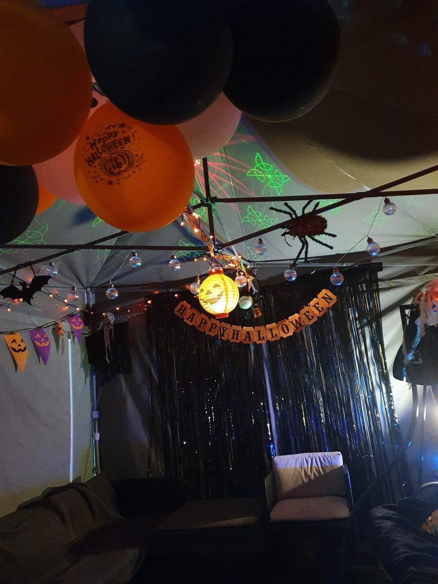 A photo taken from inside a Pop Up Gazebo decorated for halloween with balloons, streamers and buntings