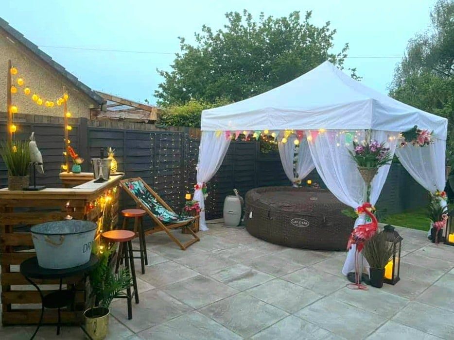 A hot tub beneath a white pop-up shelter