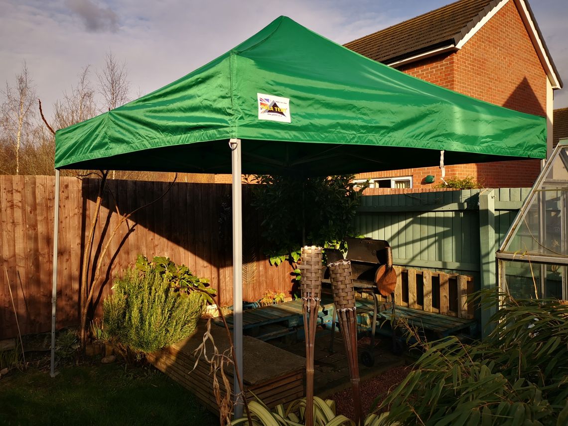 A green garden gazebo covers a seating area