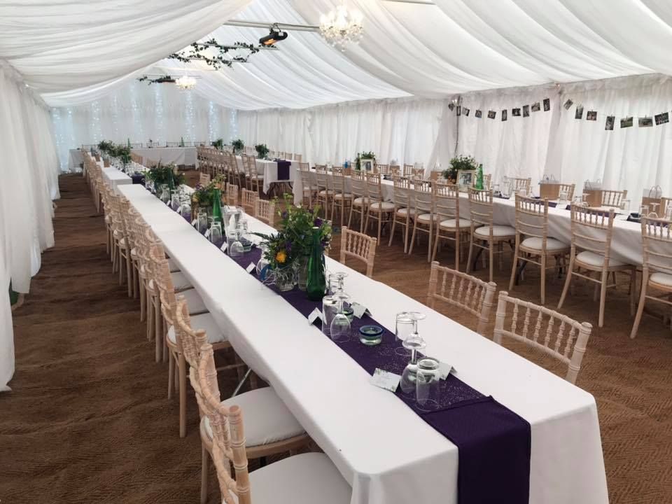 Elegantly decorated wedding marquee with long dressed tables