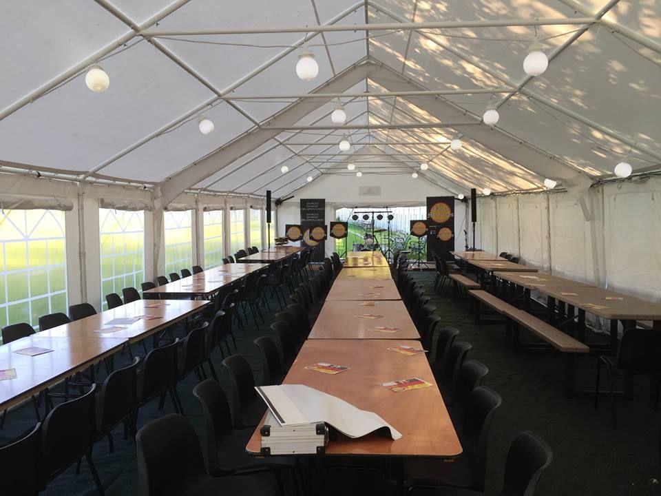 A marquee sheltering long rows of tables and seats