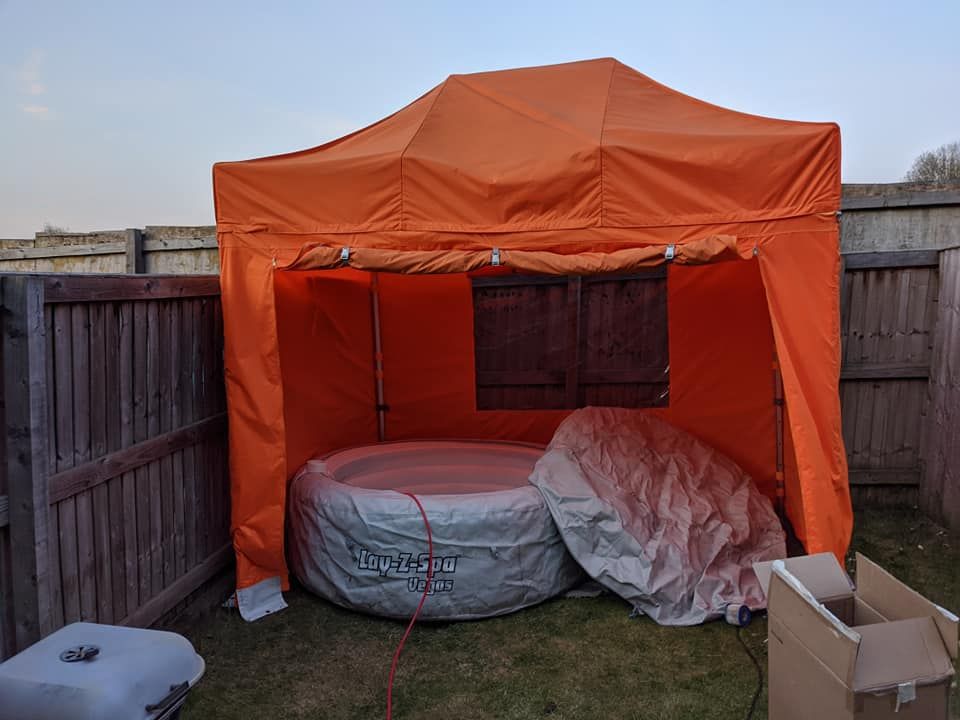 an orange gazebo covering an inflatable hot tub