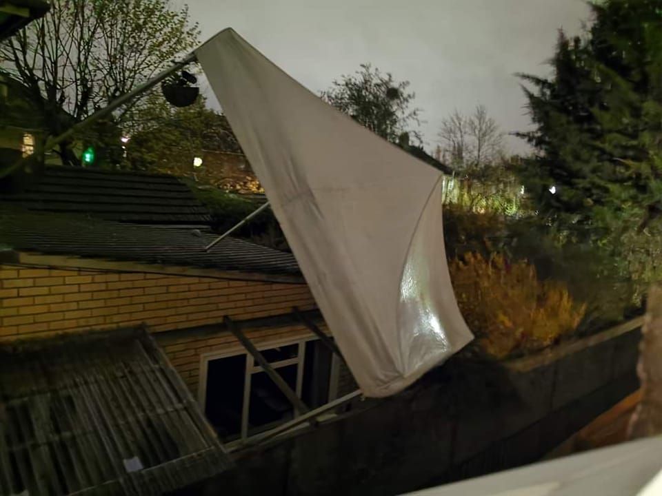 A gazebo without proper anchorage that has been blown over onto its side in the wind