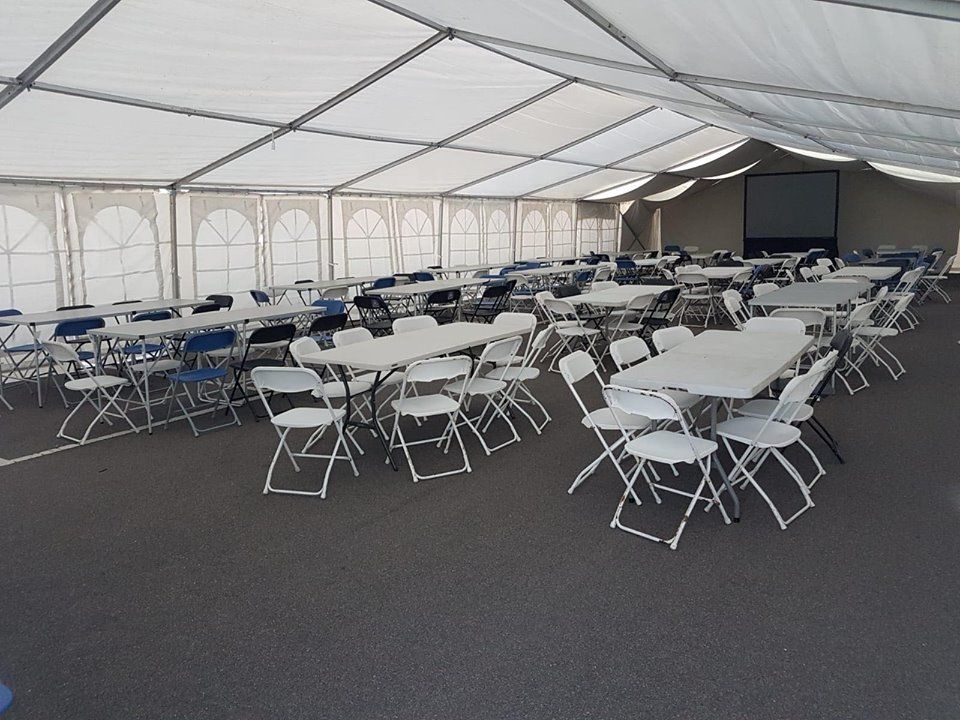 A marquee for a large corporate event with tables and chairs set up