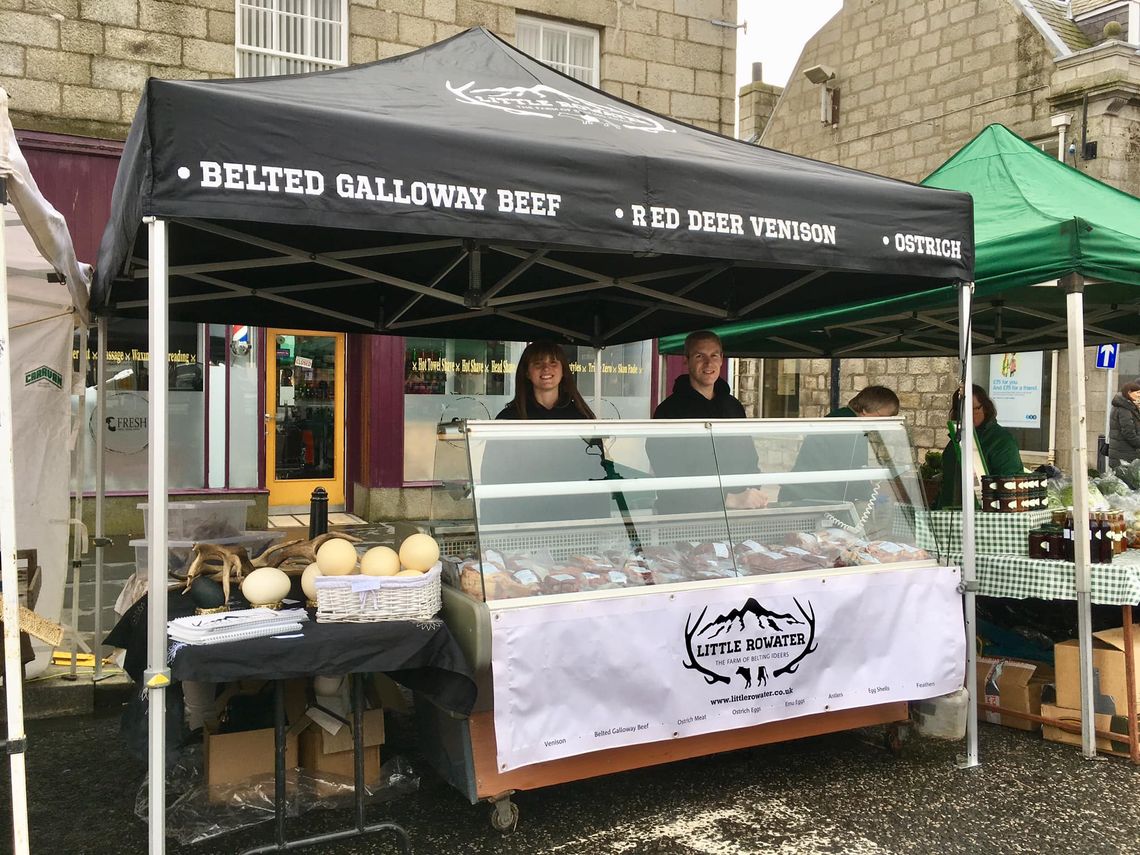 A black pop up market stall gazebo with custom printed decals