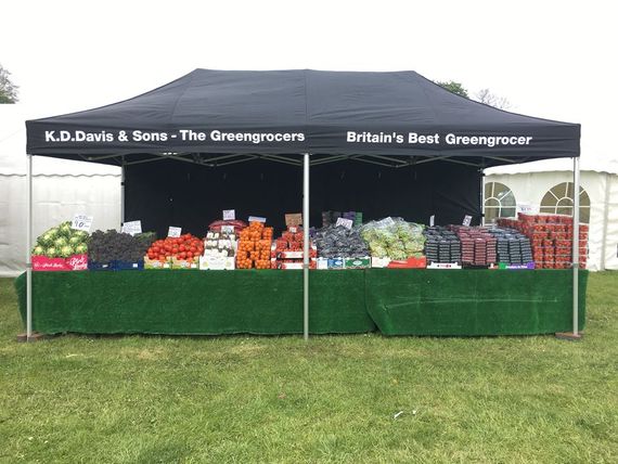Black gazebo being used as a market stall for a greengrocers