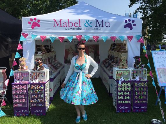 A branded white gazebo being used as a market stall selling pet accessories