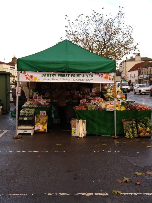 A green market stall gazebo selling fruit and veg