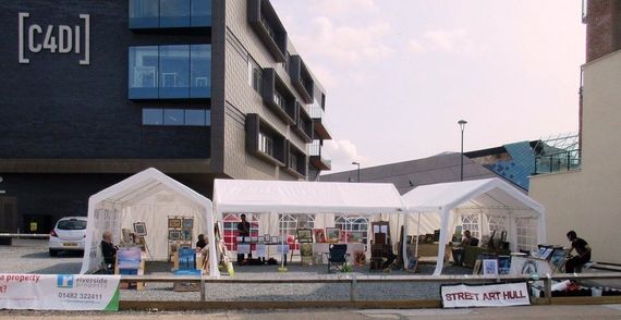 White marquee being used as shelter for selling street art