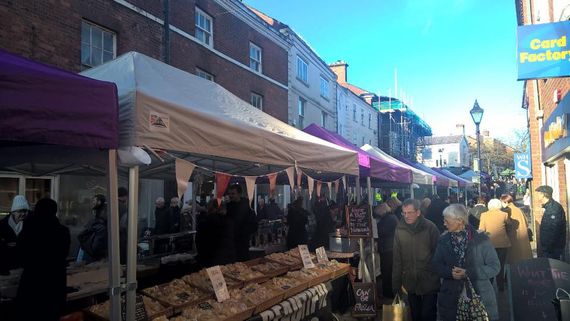 Purple and white gazebos being used as shelter for a market stall