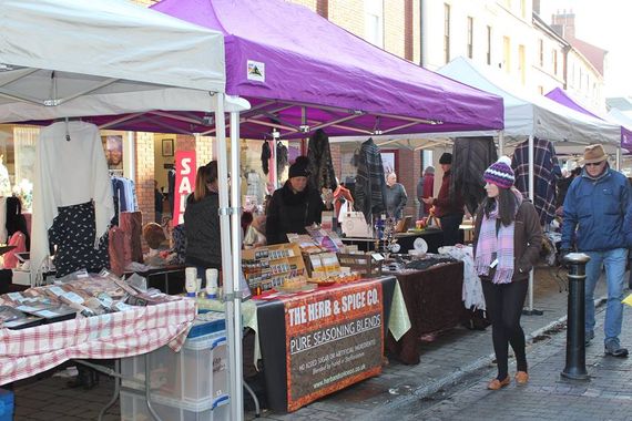 Purple and white gazebos being used as shelter for a market stall