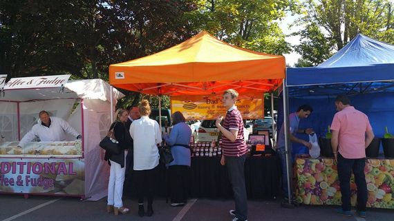 An orange gazebo at a trade show selling honey products