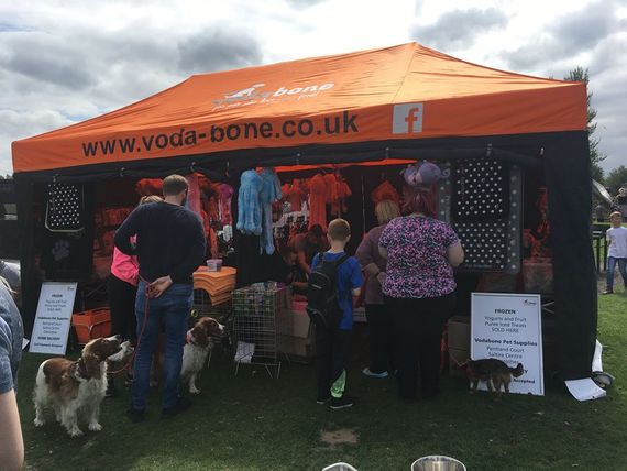 An orange gazebo with black side walls selling pet supplies