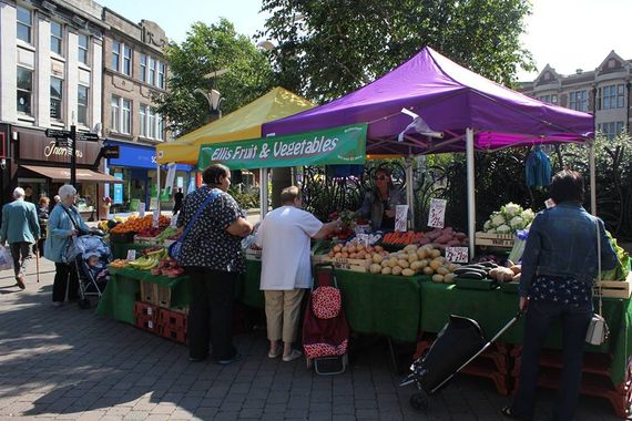 A purple and yellow gazebo used as an outdoor market stall