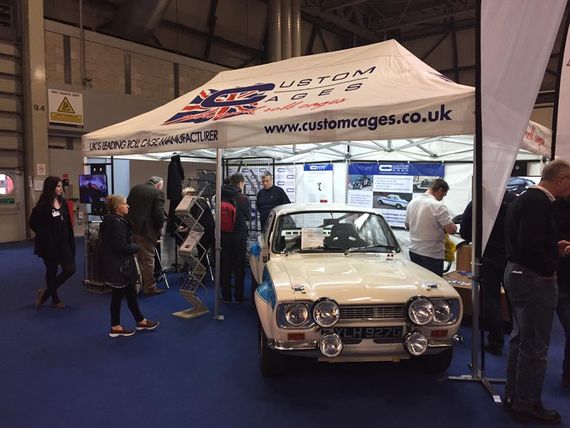 white printed autosport gazebo Pop Up Printed Motorsport Gazebo at an indoor show with a classic sports car in front