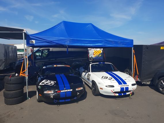 motorsport gazebo with 2 cars Blue Gala Shade Gazebo sheltering two sports cars