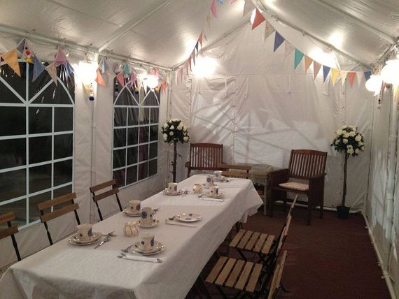 An inside view of a marquee decorated with furniture and buntings for a party