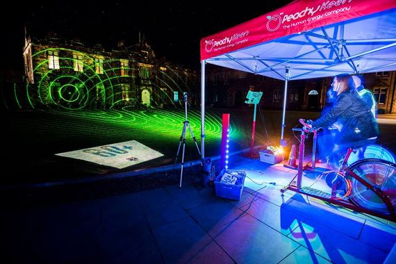 A printed gazebo for a fitness brand sheltering two cycling machines at night time