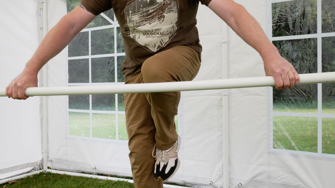 The strength of a marquee pole by Gala Tent being demonstrated by not bending easily under the owner's knee.