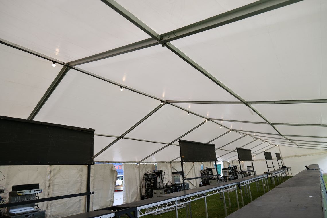 An interior view of a modular fusion commercial marquee with trade show tables lining one side