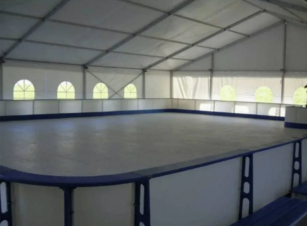 An ice rink inside a large storage tent