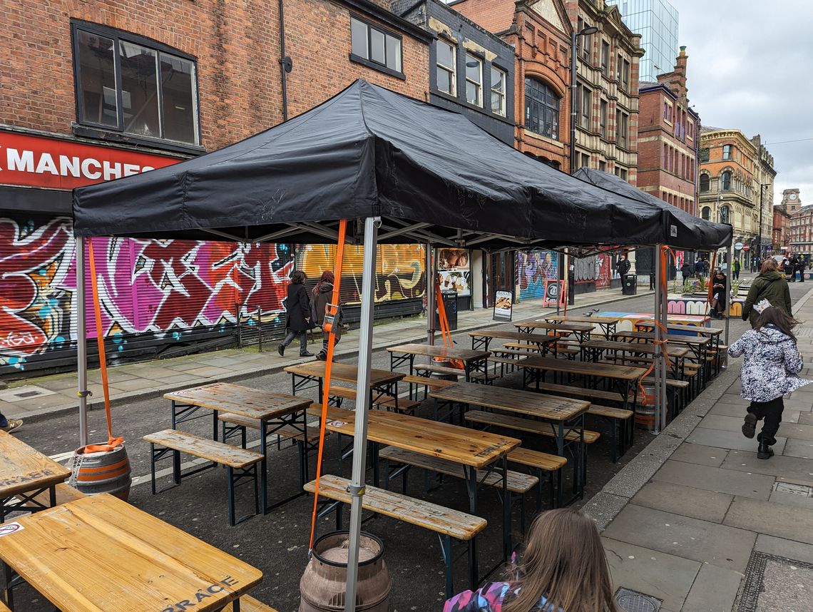 Black pop up marquee over pub benches