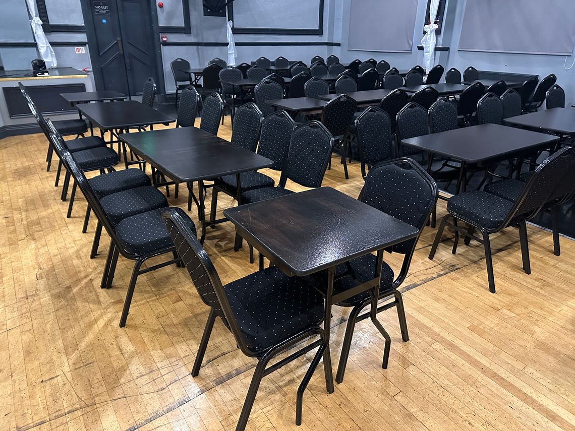 A series of black tables and chairs in a hospitality venue