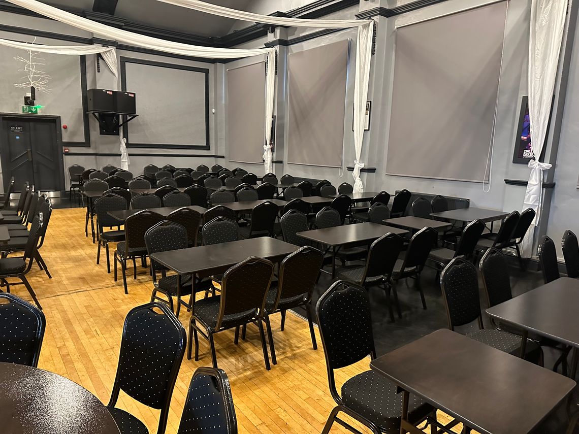 Rows of black banqueting suite furniture in a venue