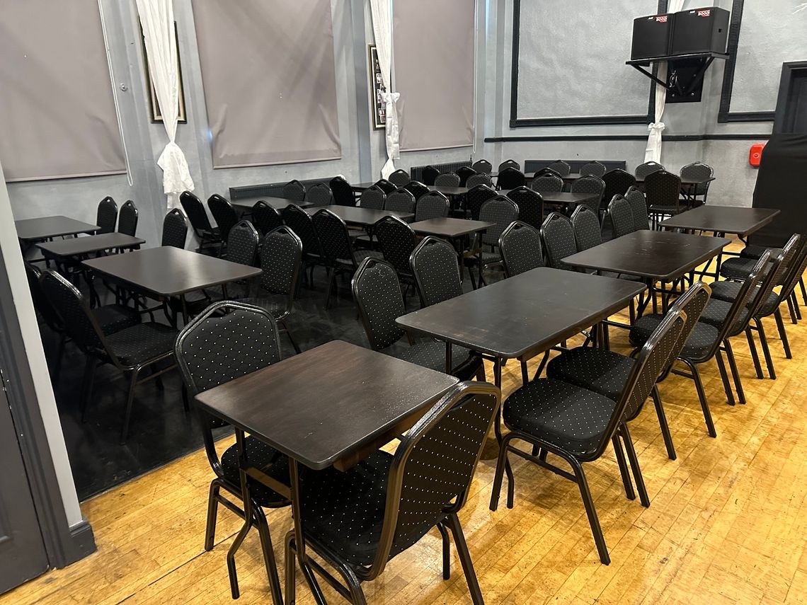 A series of black tables and chairs conference furniture in a ballroom