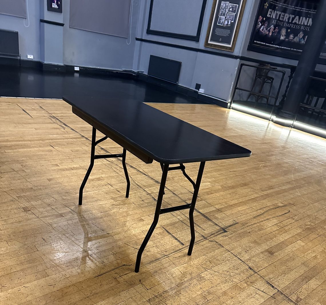 A black table with folding legs for conferences and banquets